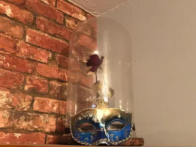 a mask with a flower in a glass cylinder at The Clacks Rustic Abode in Tillicoultry