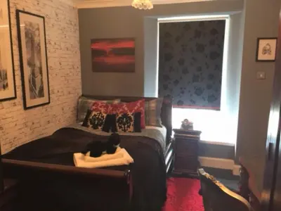 a cat laying on a bed in a bedroom at The Clacks Rustic Abode in Tillicoultry