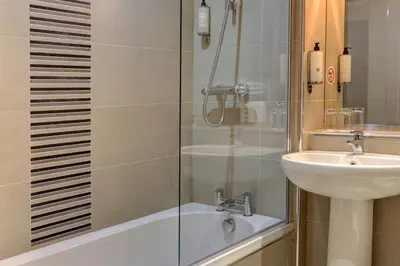 a bathroom with a shower and a sink and a tub at Best Western The Hilcroft Hotel West Lothian in Whitburn