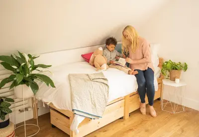 a woman and a child sitting on a bed with a teddy bear at Forty Winks Loch Lomond in Balloch