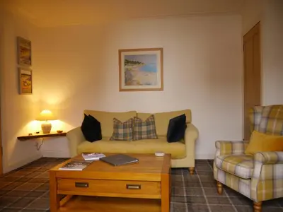 a living room with a couch and a coffee table at Cameron Cottage in Inverkip