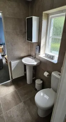 a bathroom with a sink and a toilet and a window at Balmaha Lodges and Apartments in Balmaha