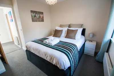 a bedroom with a large bed with two stuffed animals on it at Balmaha Lodges and Apartments in Balmaha
