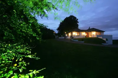 a house with lights on in a yard at night at Ayrs and Graces - Luxury Bed and Breakfast in Ayr