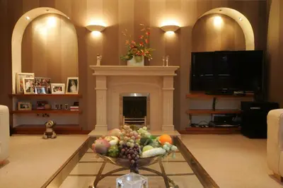 a living room with a fireplace and a bowl of fruit at Ayrs and Graces - Luxury Bed and Breakfast in Ayr