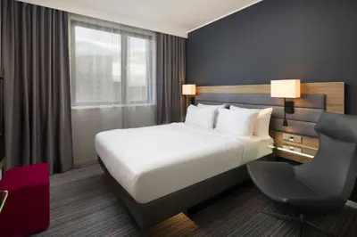 a hotel room with a bed and a chair at Moxy Glasgow Merchant City in Glasgow