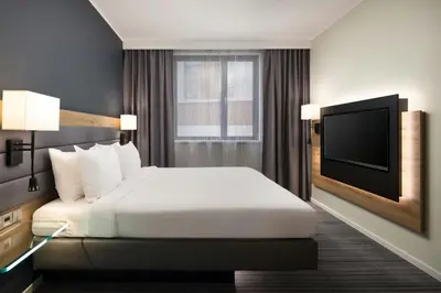 a hotel room with a bed and a flat screen tv at Moxy Glasgow Merchant City in Glasgow