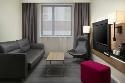a living room with a couch and a tv at Moxy Glasgow Merchant City in Glasgow