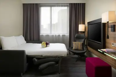a hotel room with a bed and a tv at Moxy Glasgow Merchant City in Glasgow