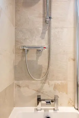 a shower in a bathroom with a sink at 2 bedroom lodge with free WiFi and mountain view in Crianlarich
