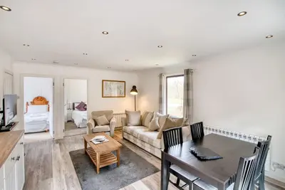 a living room with a table and a couch at 2 bedroom lodge with free WiFi and mountain view in Crianlarich