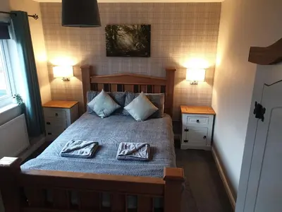 a bedroom with a bed with two towels on it at Oldwood Place Townhouse in Livingston