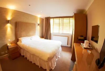 a hotel room with a large bed and a window at Abbotsford Hotel in Dumbarton