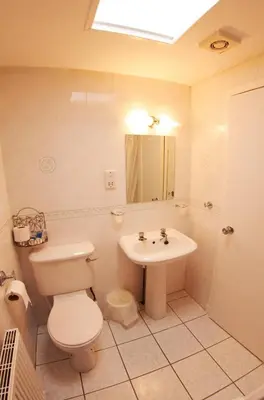 a bathroom with a toilet and a sink at Abbotsford Hotel in Dumbarton