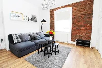 a living room with a couch and a brick wall at Stylish Flat in 1860's Listed Building in Edinburgh