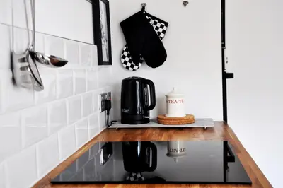 a kitchen counter with a coffee maker and an umbrella at Stylish Flat in 1860's Listed Building in Edinburgh