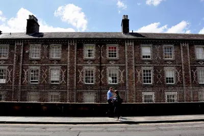 a man and woman standing in front of a large brick building at Stylish Flat in 1860's Listed Building in Edinburgh
