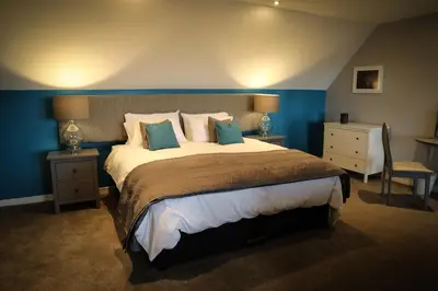 a bedroom with a large bed with blue walls at Bay and Bridge near Edinburgh in Dunfermline