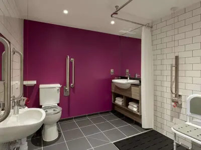 a purple bathroom with a toilet and a sink at ibis Styles Glasgow Central in Glasgow