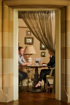 a man and woman sitting at a table in a room at Cairn Lodge in Auchterarder