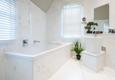 a white bathroom with a tub and a sink at Cairn Lodge in Auchterarder