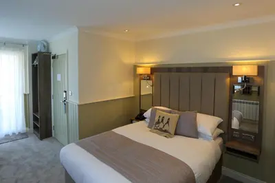 a bedroom with a large bed in a room at Duck Bay Hotel & Restaurant in Balloch
