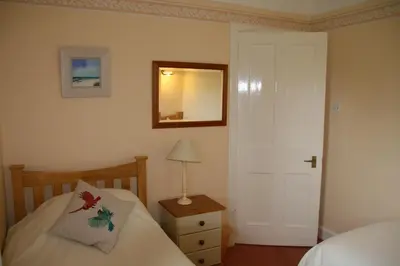a bedroom with a bed and a mirror on the wall at Laich Cottage in Appin
