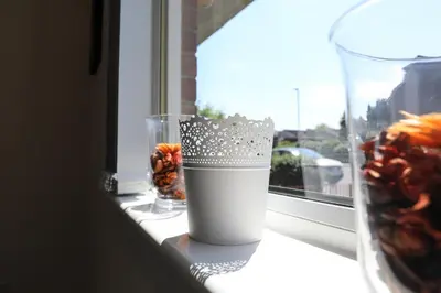 a vase sitting on a window sill with a drink at Netherton House in Wishaw