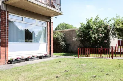 a house with a window with flowers in a yard at Netherton House in Wishaw