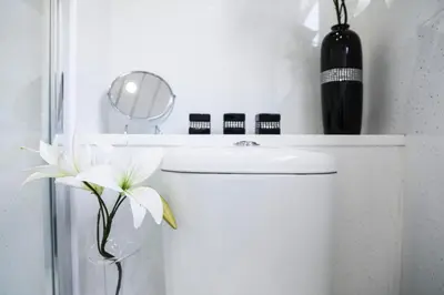 a white bathroom with a sink and a mirror at Netherton House in Wishaw