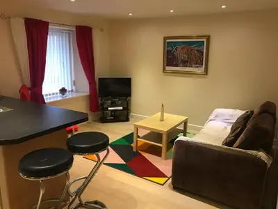 a living room with a couch and a table at Nelson Seaside Apartment in Largs
