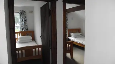 a room with two bunk beds and a mirror at Craobh Marina Cottages in Craobh Haven