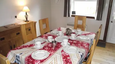 a dining room table with a red and white table cloth at Craobh Marina Cottages in Craobh Haven