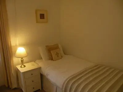 a small bedroom with a bed and a lamp on a night stand at Thistle House Guest House in Saint Catherines