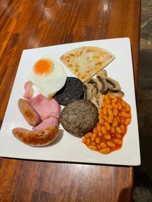 a plate of food with eggs sausage beans and bread at Thistle House Guest House in Saint Catherines