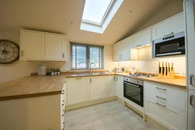 a kitchen with white cabinets and a skylight at Balloch Park in Aberfeldy