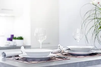 a table with two plates and wine glasses on it at PREMIER SUITES PLUS Glasgow George Square in Glasgow