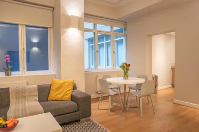 a living room with a couch and a table at PREMIER SUITES PLUS Glasgow George Square in Glasgow