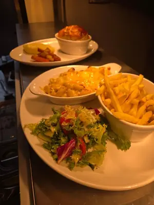 a table with three plates of food and french fries at The Old Schoolhouse Hotel in Larkhall