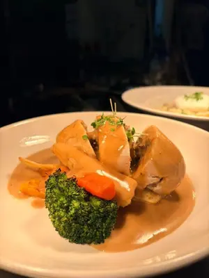 a plate of food with chicken and broccoli on a table at The Old Schoolhouse Hotel in Larkhall