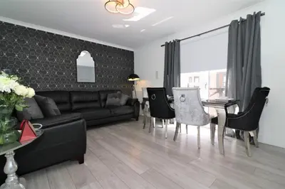 a living room with a couch and a table and chairs at 2 Bedroom Apartment at SECC Hydro FREE PARKING in Glasgow