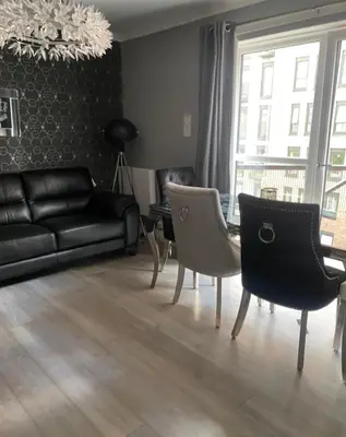 a living room with a black couch and chairs at 2 Bedroom Apartment at SECC Hydro FREE PARKING in Glasgow