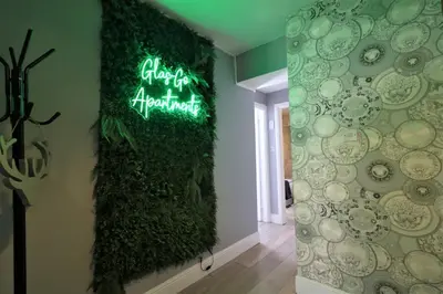 a room with a green wall with a sign on it at 2 Bedroom Apartment at SECC Hydro FREE PARKING in Glasgow
