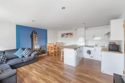 a kitchen and living room with a couch and a table at Wallace's Rest in Stirling