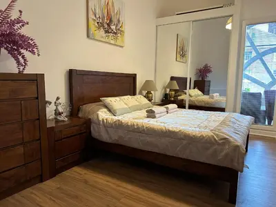a bedroom with a bed and a dresser and a window at Stunning 2 bedroom apartment in Glasgow