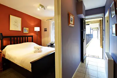 a bedroom with a bed and a door to a balcony at JOIVY Bohemian Writers Retreat in Old Town in Edinburgh