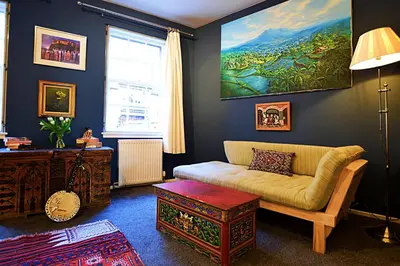 a living room with a couch and a painting on the wall at JOIVY Bohemian Writers Retreat in Old Town in Edinburgh