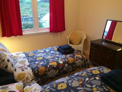 a bedroom with a bed and a tv and a window at Ardminish House Gigha in Isle of Gigha