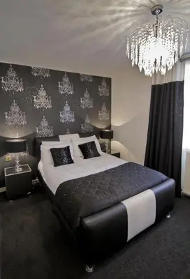 a bedroom with a large bed and a chandelier at The Burnside Hotel in Glasgow