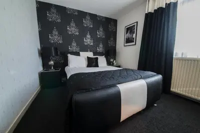 a bedroom with a bed and a black and white wall at The Burnside Hotel in Glasgow